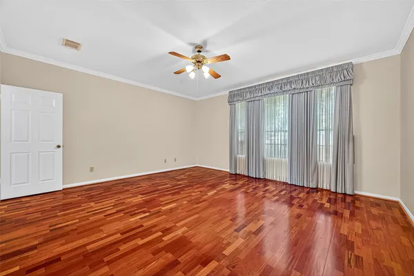a view of a room with wooden floor and a ceiling fan