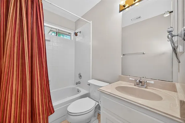 a bathroom with a sink a toilet and shower curtain