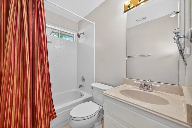 a bathroom with a sink a toilet and shower curtain