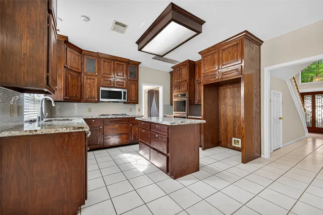 a kitchen with stainless steel appliances granite countertop a refrigerator and a stove