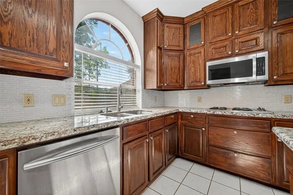 a kitchen with stainless steel appliances granite countertop a stove microwave and cabinets