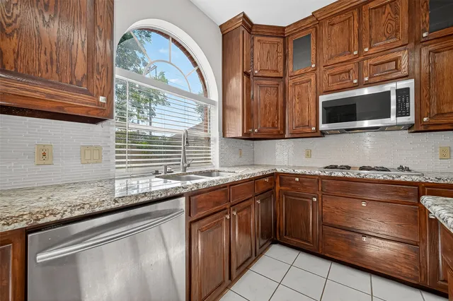 a kitchen with stainless steel appliances granite countertop a stove microwave and cabinets
