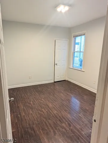 an empty room with wooden floor and window