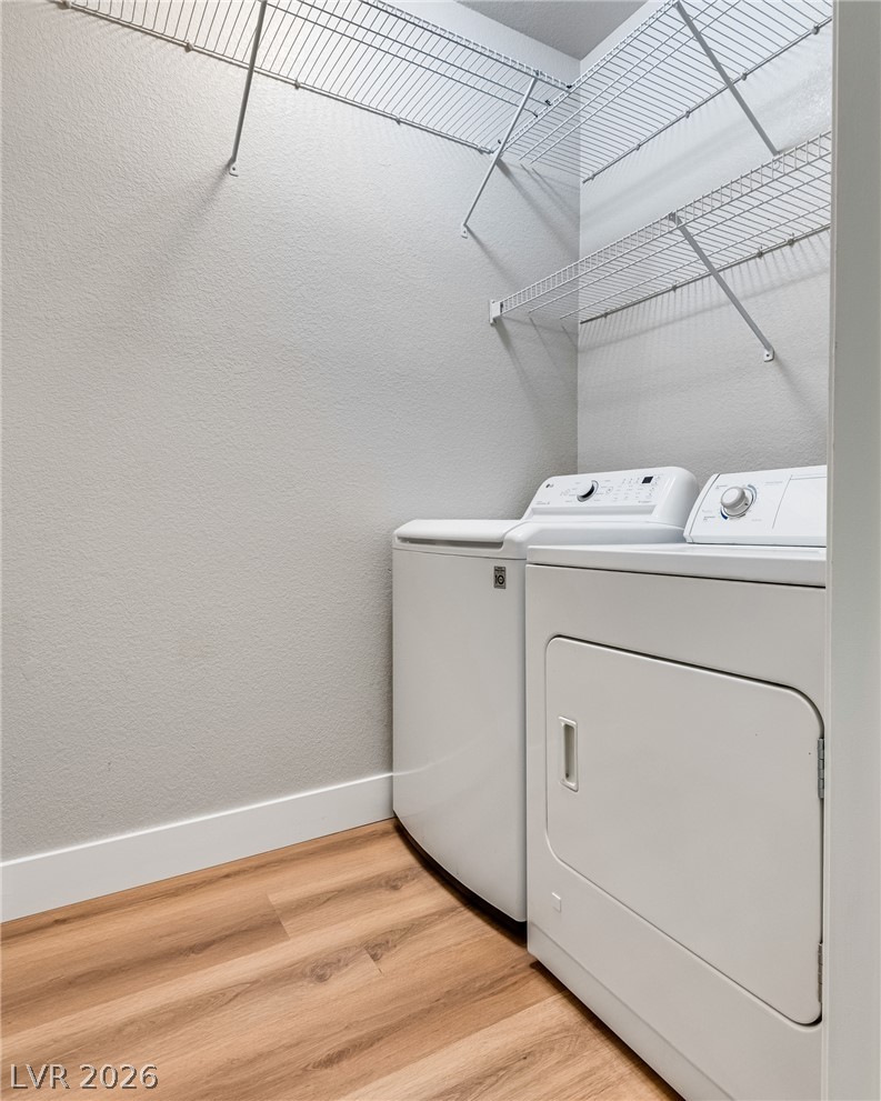 10550 West Alexander Road, Unit 2174 Las Vegas, NV 89129 - Photo 21 of 28 A functional laundry space highlights wood floors and built-in shelving overhead.