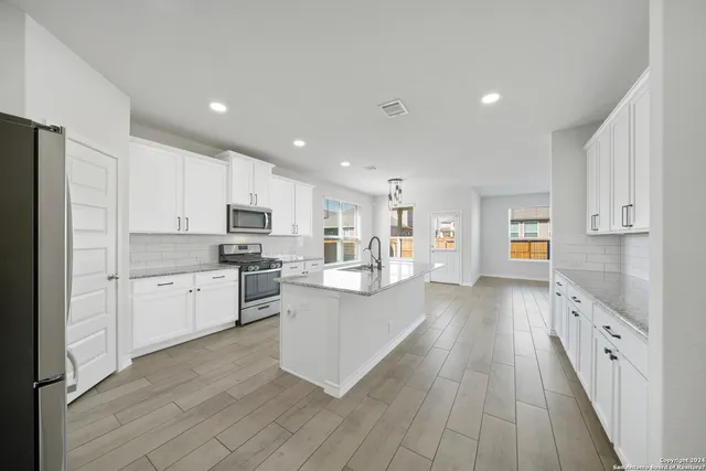 a kitchen with white cabinets and stainless steel appliances
