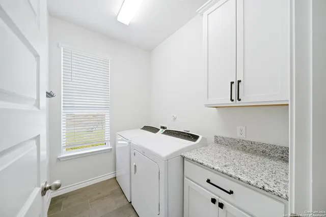 a utility room with cabinets washer and dryer