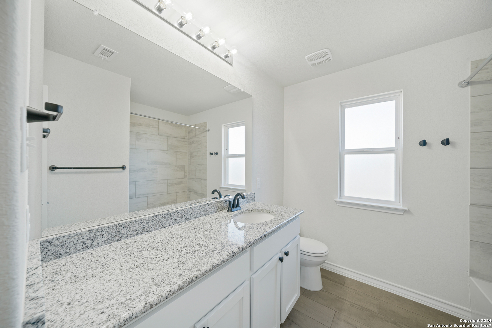 648 Amber Creek Cibolo, TX 78108 - Photo 28 of 34 a bathroom with a granite countertop sink a toilet and shower
