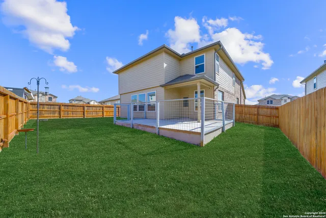 a view of a house with a big yard and a large tree
