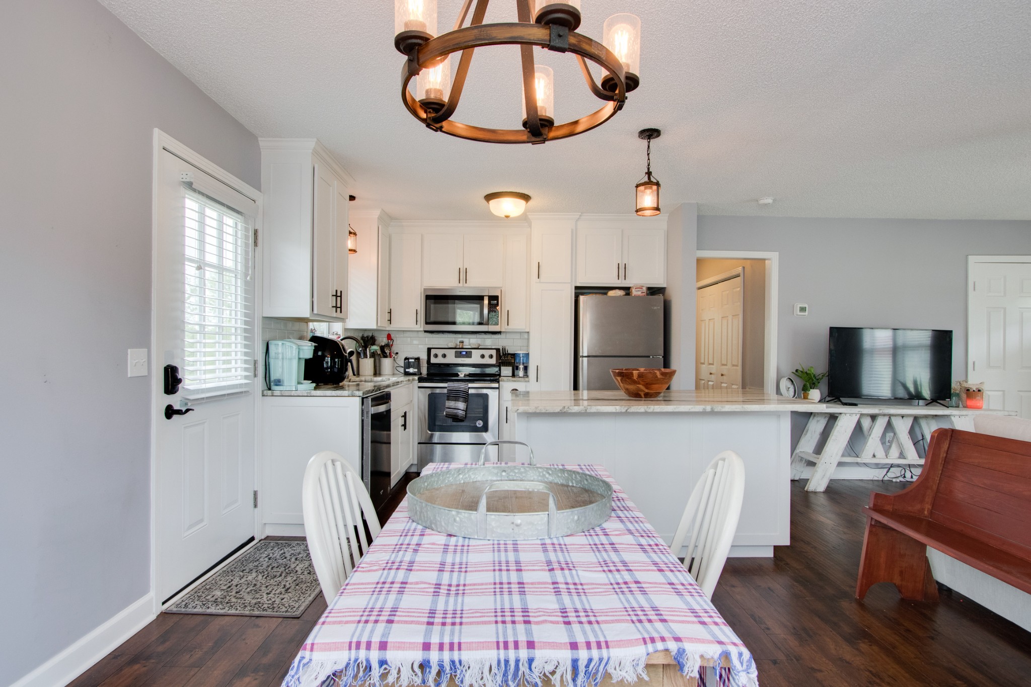 576 Bellwood Road Lebanon, TN 37087 - Photo 21 of 34 a kitchen with stainless steel appliances a stove a refrigerator a sink a dining table and chairs with wooden floor