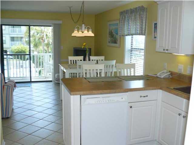 3799 Hwy Santa Rosa Beach, Unit 10B 30A Santa Rosa Beach, FL 32459 - Photo 11 of 16 a kitchen with sink cabinets and dining table