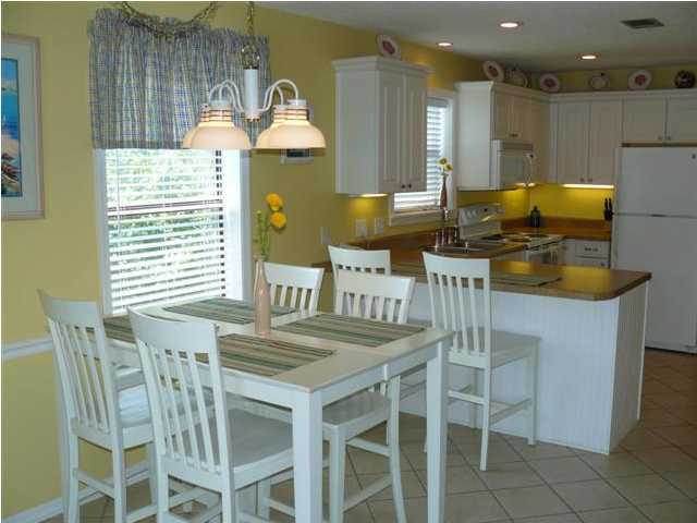 3799 Hwy Santa Rosa Beach, Unit 10B 30A Santa Rosa Beach, FL 32459 - Photo 10 of 16 a kitchen with a table chairs and a stove