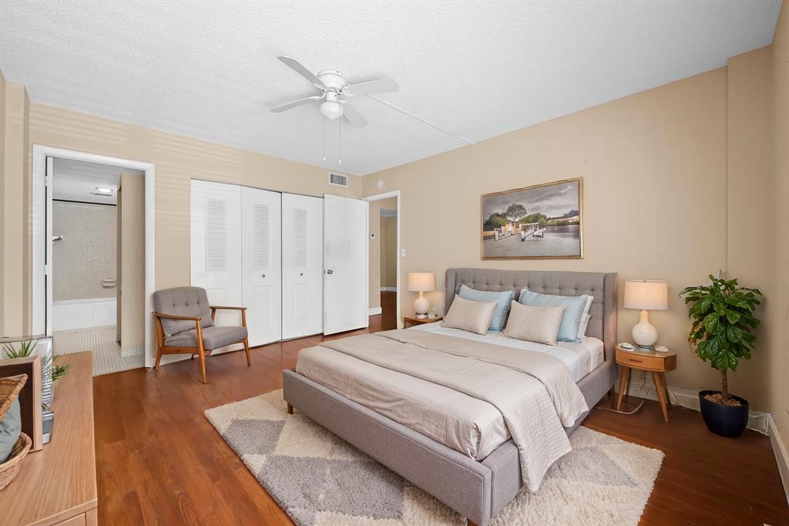 4156 Inverrary Drive, Unit 210 Lauderhill, FL 33319 - Photo 10 of 27 a bedroom with a large bed and a chandelier