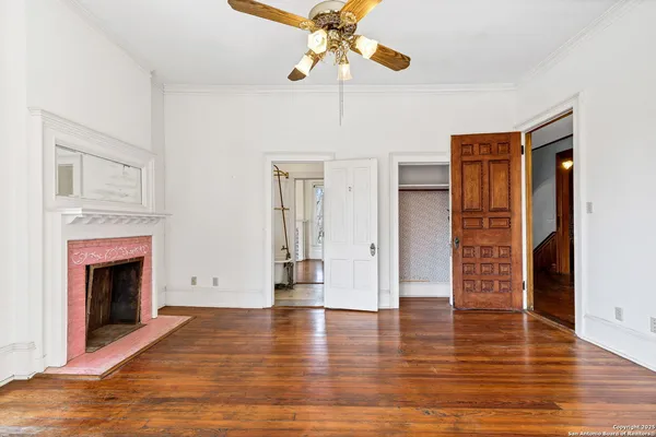 a view of a hallway with wooden floor and staircase
