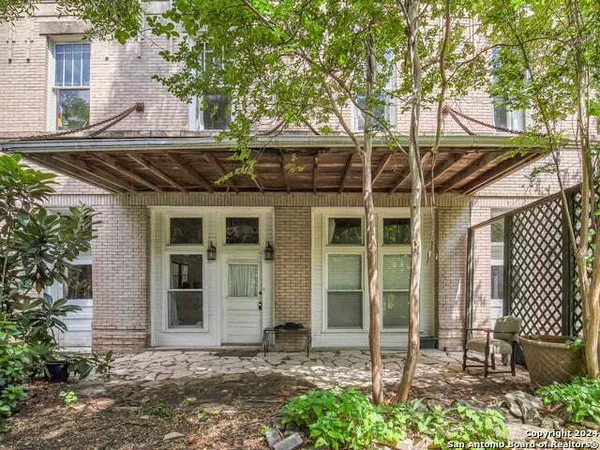 a front view of a house with a yard and palm trees