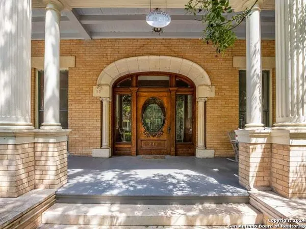a view of front door with entryway and wooden floor