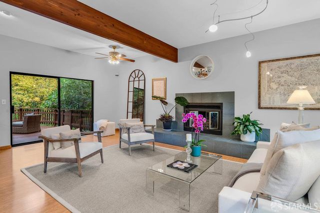 a living room with fireplace furniture and a large window
