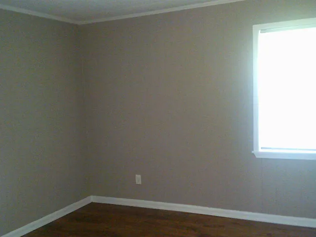 a view of a small space with wooden floor and a window