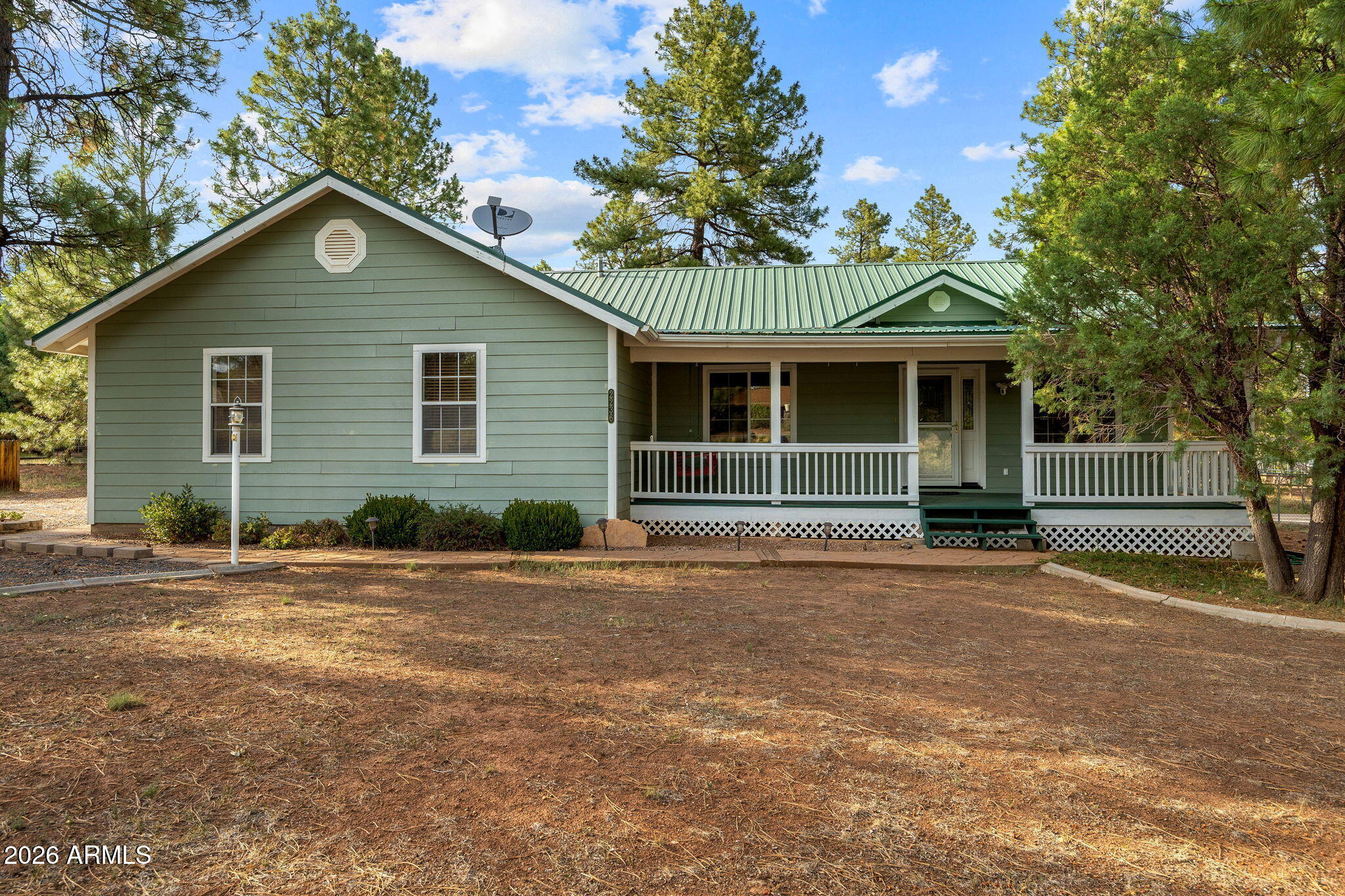 2236 Cross Country Road Overgaard, AZ 85933 - Photo 2 of 59 a front view of a house with a garden and trees
