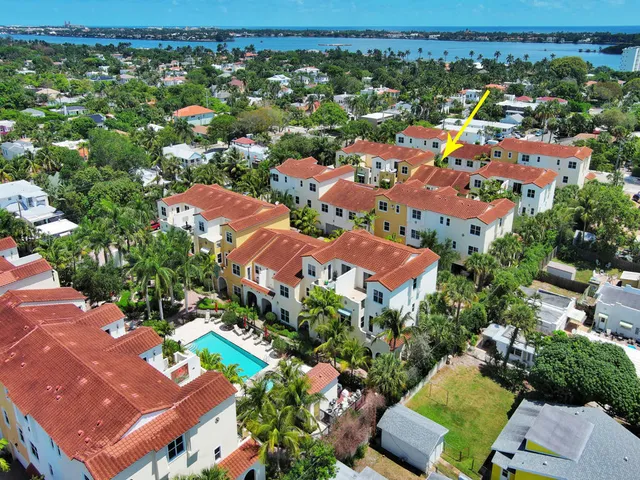 an aerial view of residential houses with outdoor space and trees