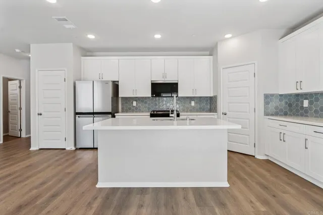 a kitchen with white cabinets and white appliances