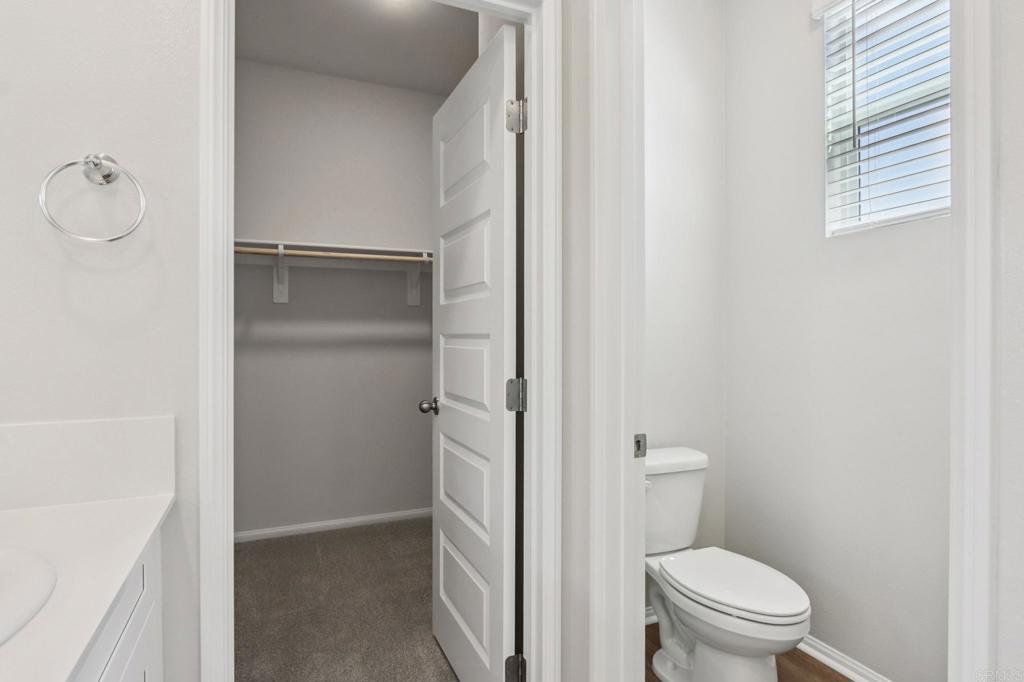 28424 Campos De Flores Temecula, CA 92591 - Photo 30 of 36 a bathroom with a granite countertop toilet and a shower