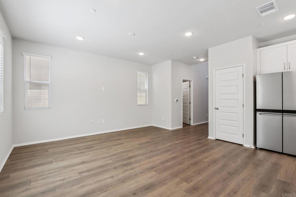 28424 Campos De Flores Temecula, CA 92591 - Photo 7 of 36 a view of an empty room with wooden floor kitchen and a window