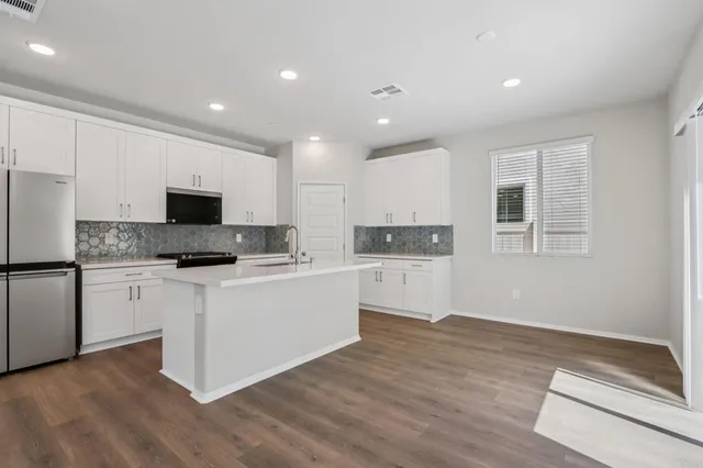 a kitchen with white cabinets and stainless steel appliances