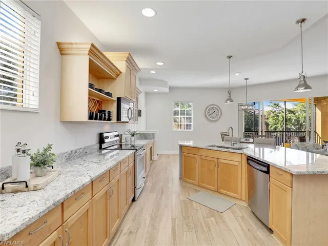 a kitchen with stainless steel appliances granite countertop a sink stove and cabinets