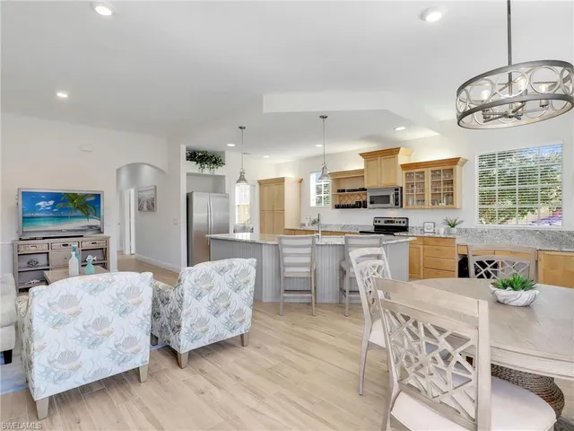 a large kitchen with cabinets wooden floor and stainless steel appliances
