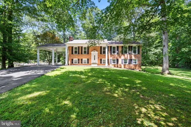 a view of a house with a big yard and large trees