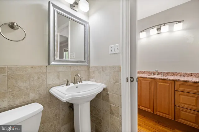 a bathroom with a sink a toilet and mirror