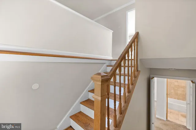 a view of staircase with wooden floor and white walls