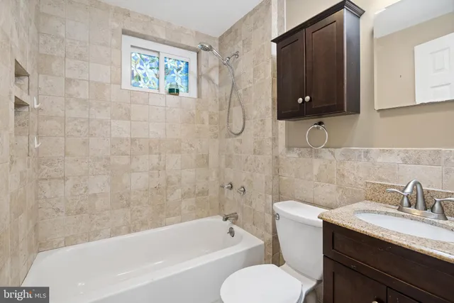 a bathroom with a granite countertop toilet sink and bathtub