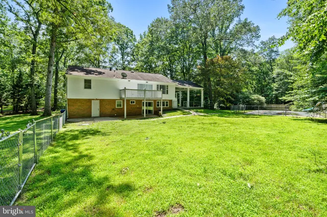 a view of a house with a big yard and large trees
