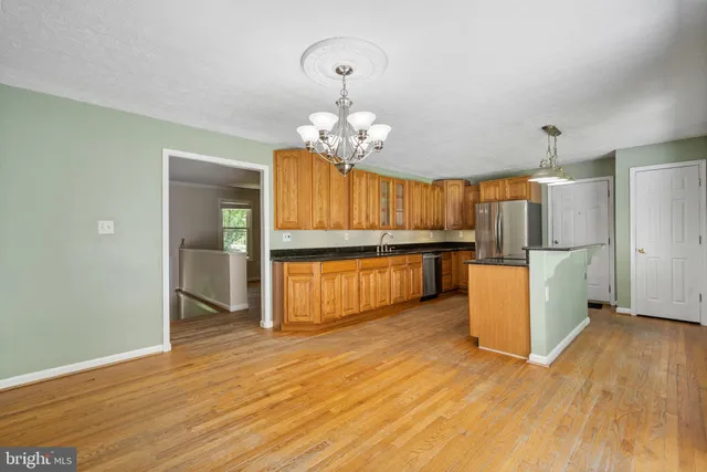 a view of kitchen with granite countertop cabinets and refrigerator