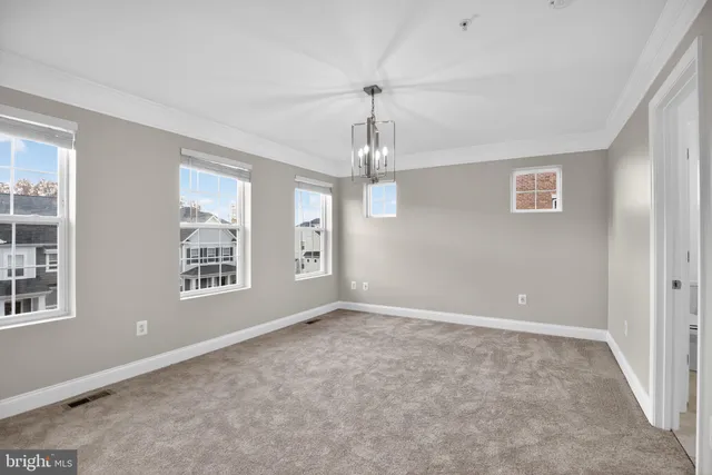 an empty room with windows and chandelier