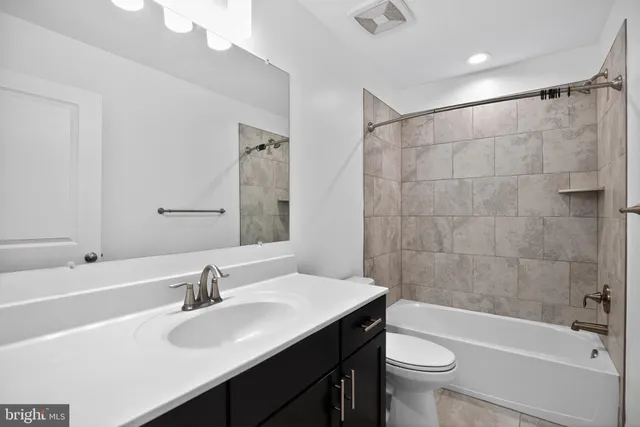 a bathroom with a sink a toilet a mirror a bathtub and shower