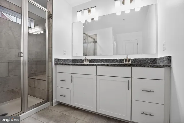 a bathroom with a granite countertop sink and a mirror