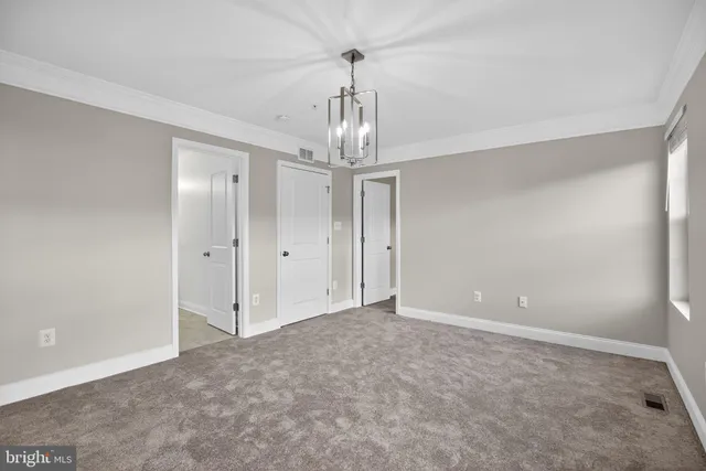 a view of empty room with window and chandelier