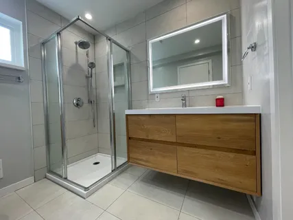 a bathroom with a shower sink and mirror