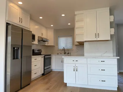 a kitchen with stainless steel appliances granite countertop a refrigerator and cabinets