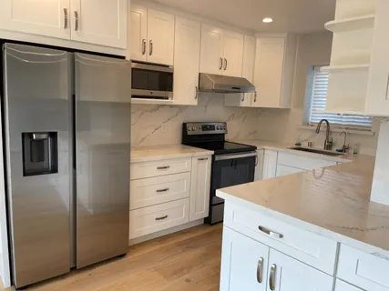 a kitchen with white cabinets and stainless steel appliances