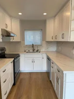 a kitchen with stainless steel appliances granite countertop a sink stove and cabinets