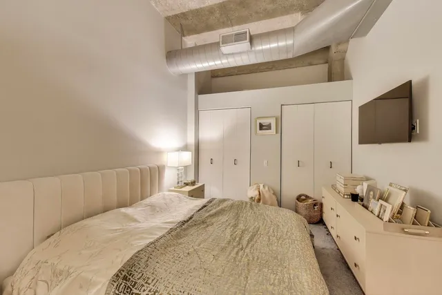 a spacious bedroom with a bed and a flat screen tv