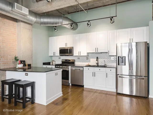 a kitchen with a sink stainless steel appliances and white cabinets