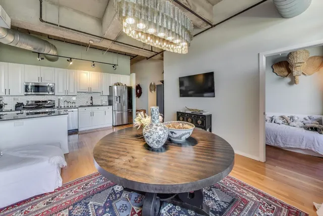 a dining room with furniture a chandelier and wooden floor