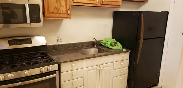 a kitchen with a refrigerator and a stove