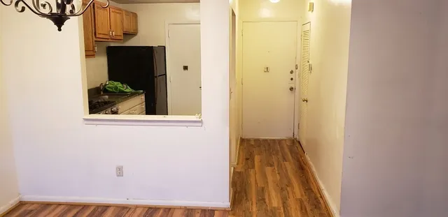 a view of a hallway with wooden floor and entryway