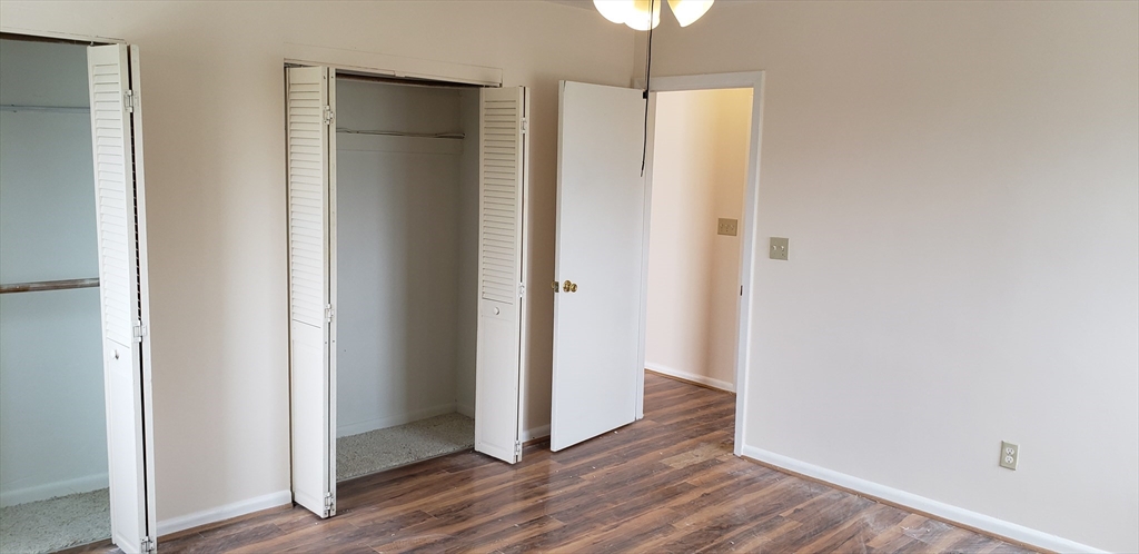 6 Hayes Road, Unit 25 Boston, MA 02131 - Photo 27 of 39 an empty room with wooden floor and a hallway