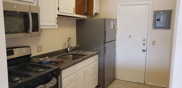 a kitchen with stainless steel appliances granite countertop a refrigerator and a stove